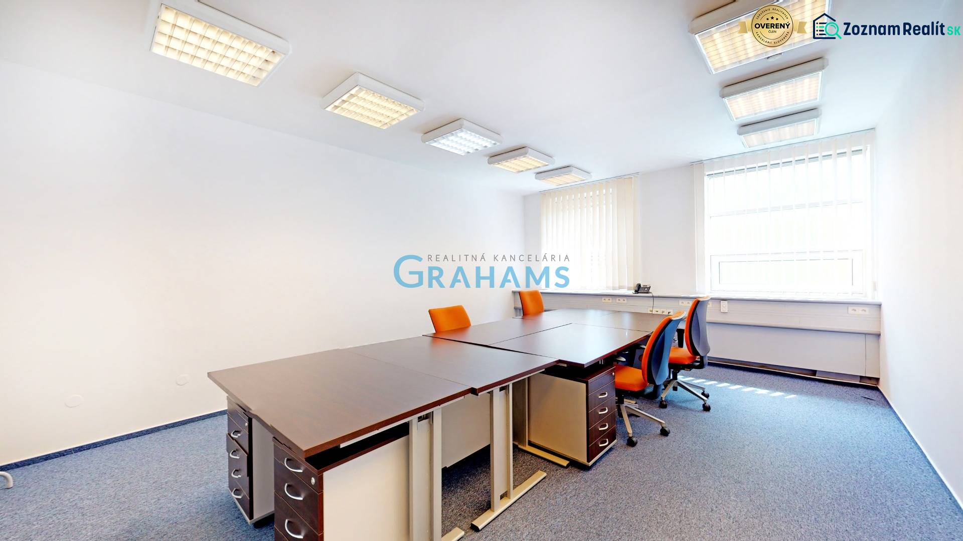 Iroda narancssárga székekkel és sarokablakkal, a helyiség függönyökkel van felszerelve.