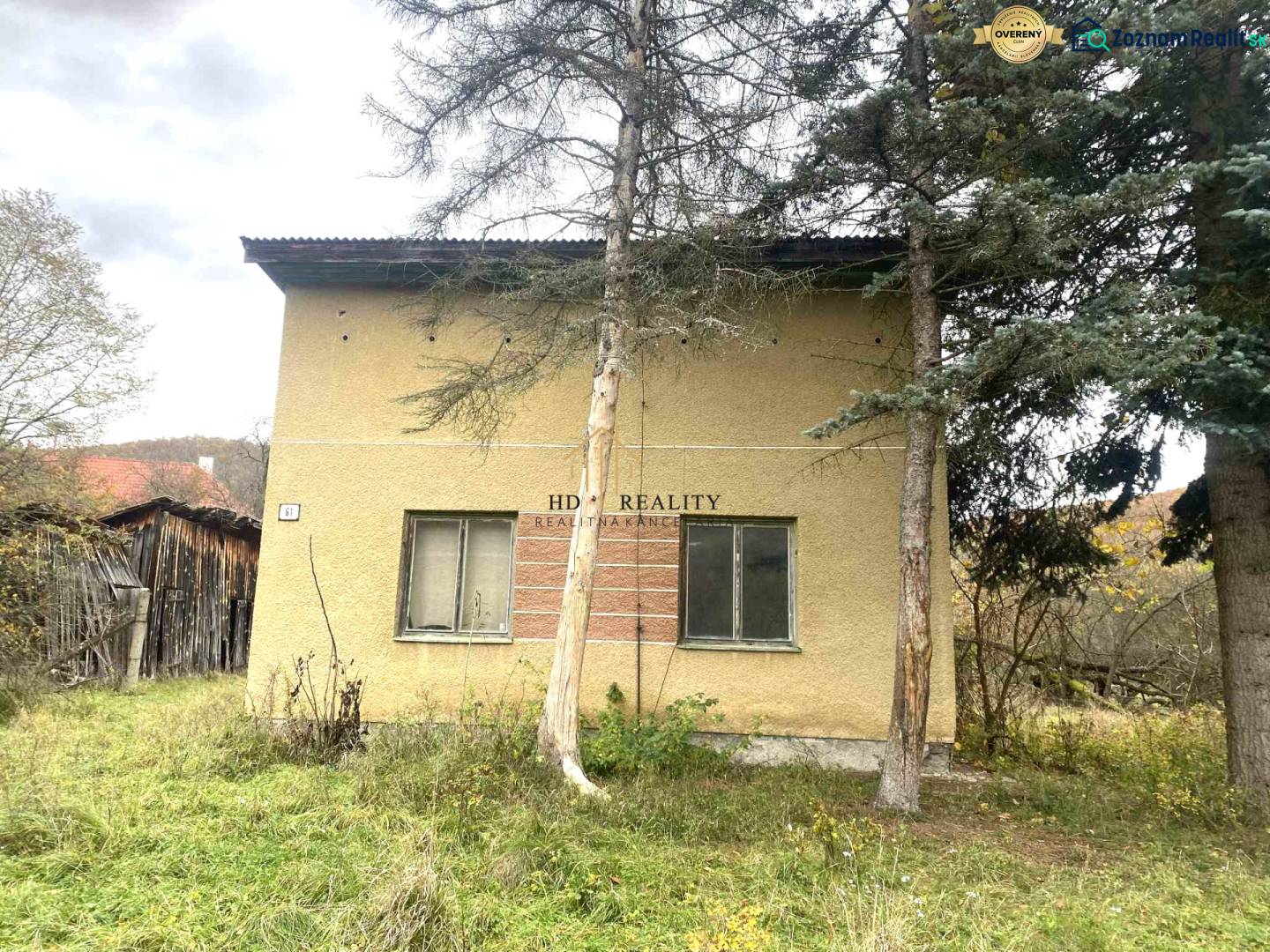 Családi ház Rykynčice-ben, fákkal körülvéve, lejtős telekkel és fa melléképülettel.