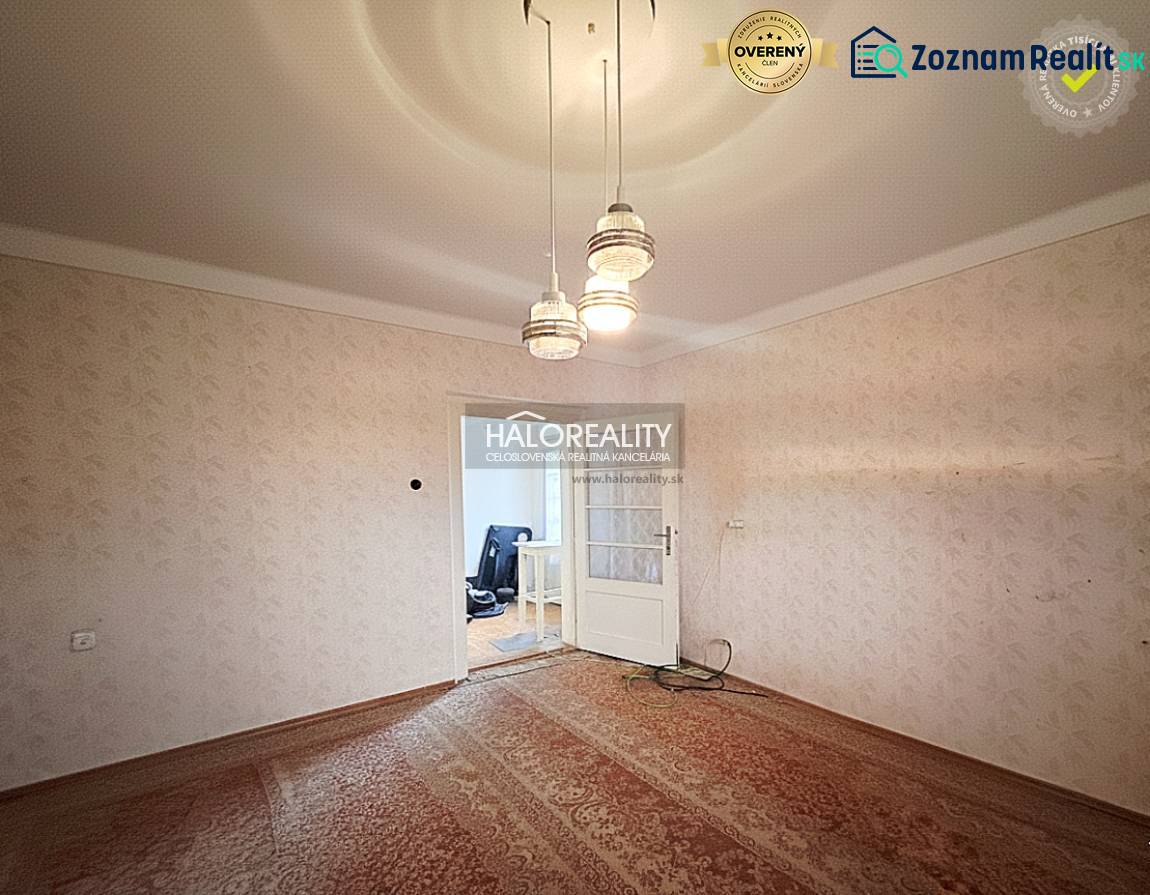 Szoba családi házban szőnyegpadlóval és függő világítással.