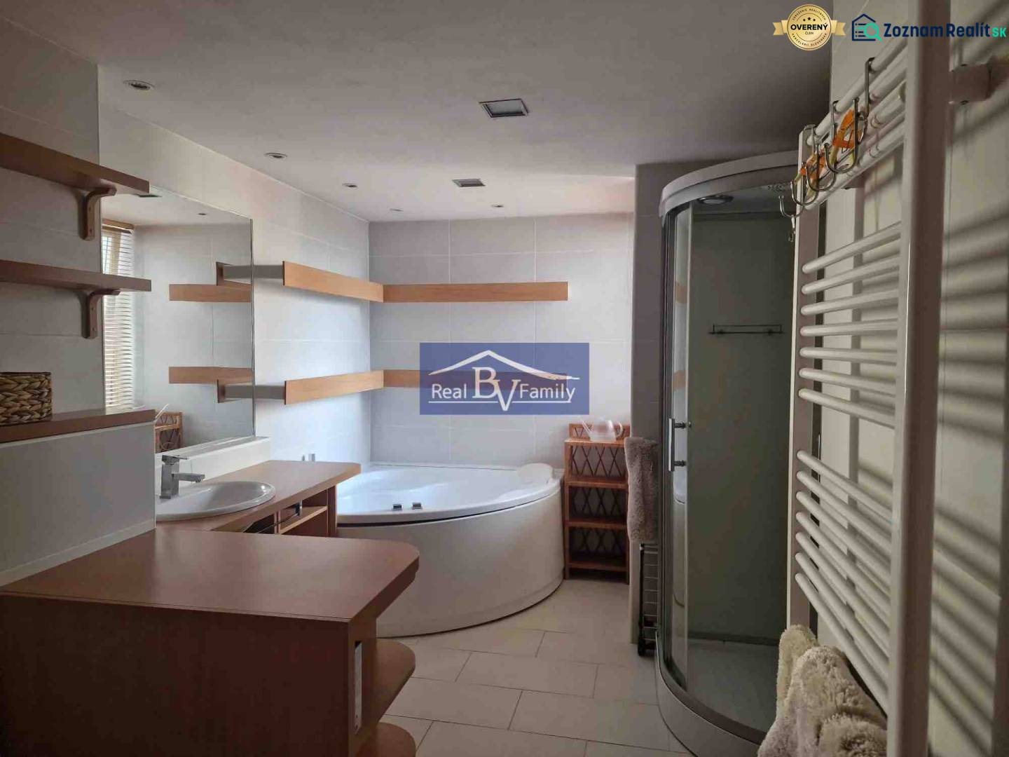 Fürdőszoba egy kétszobás lakásban, káddal, zuhanyzóval és polcokkal.