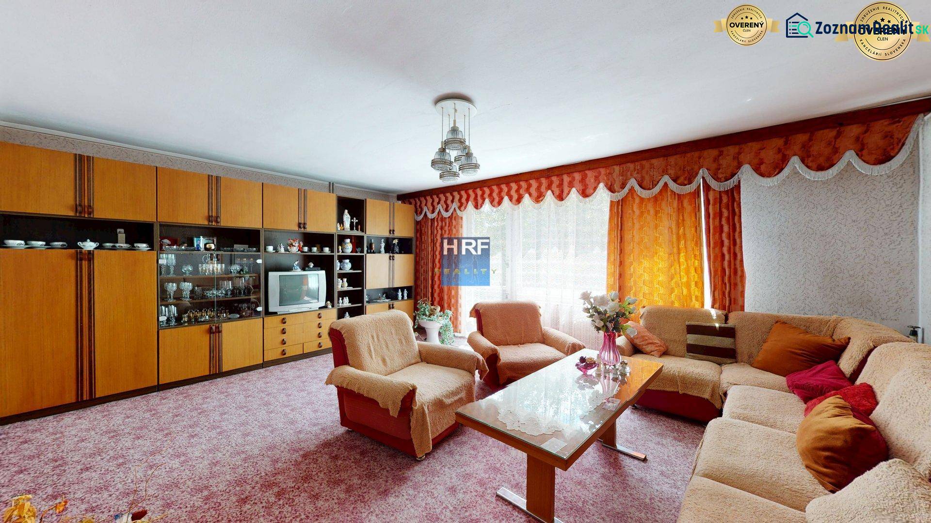 Nappali a családi házban kanapéval, nappali szekrénnyel és virágokkal.