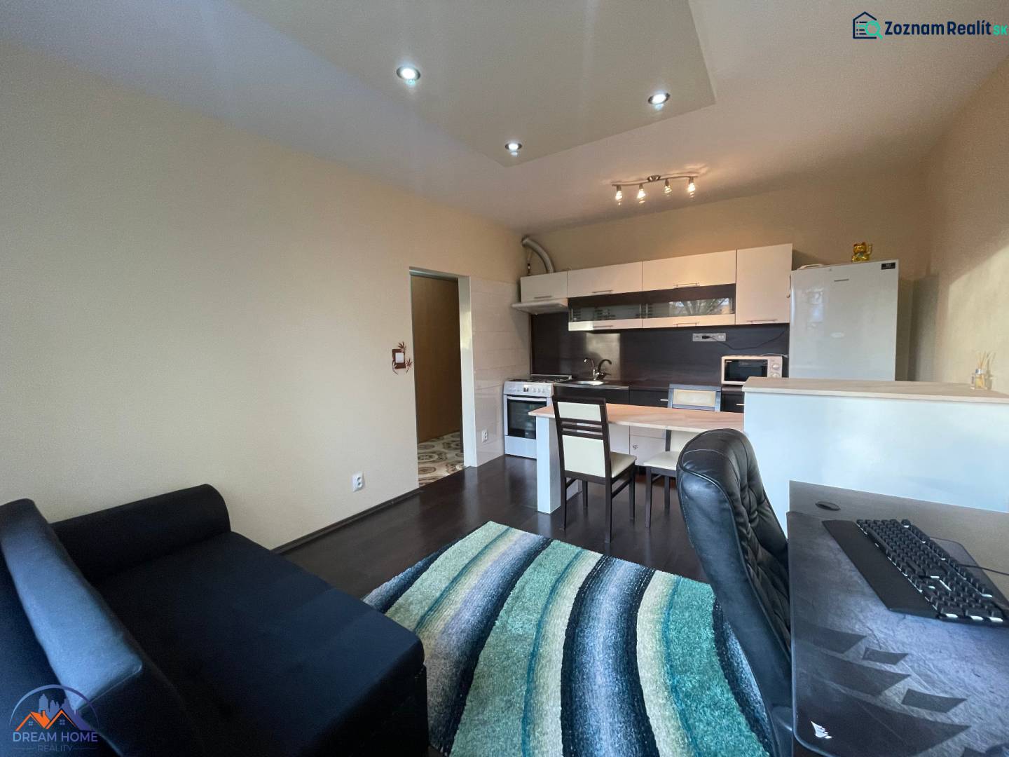 1 szobás lakás belső tere konyhasarokkal és fa dekorációjú padlóval.