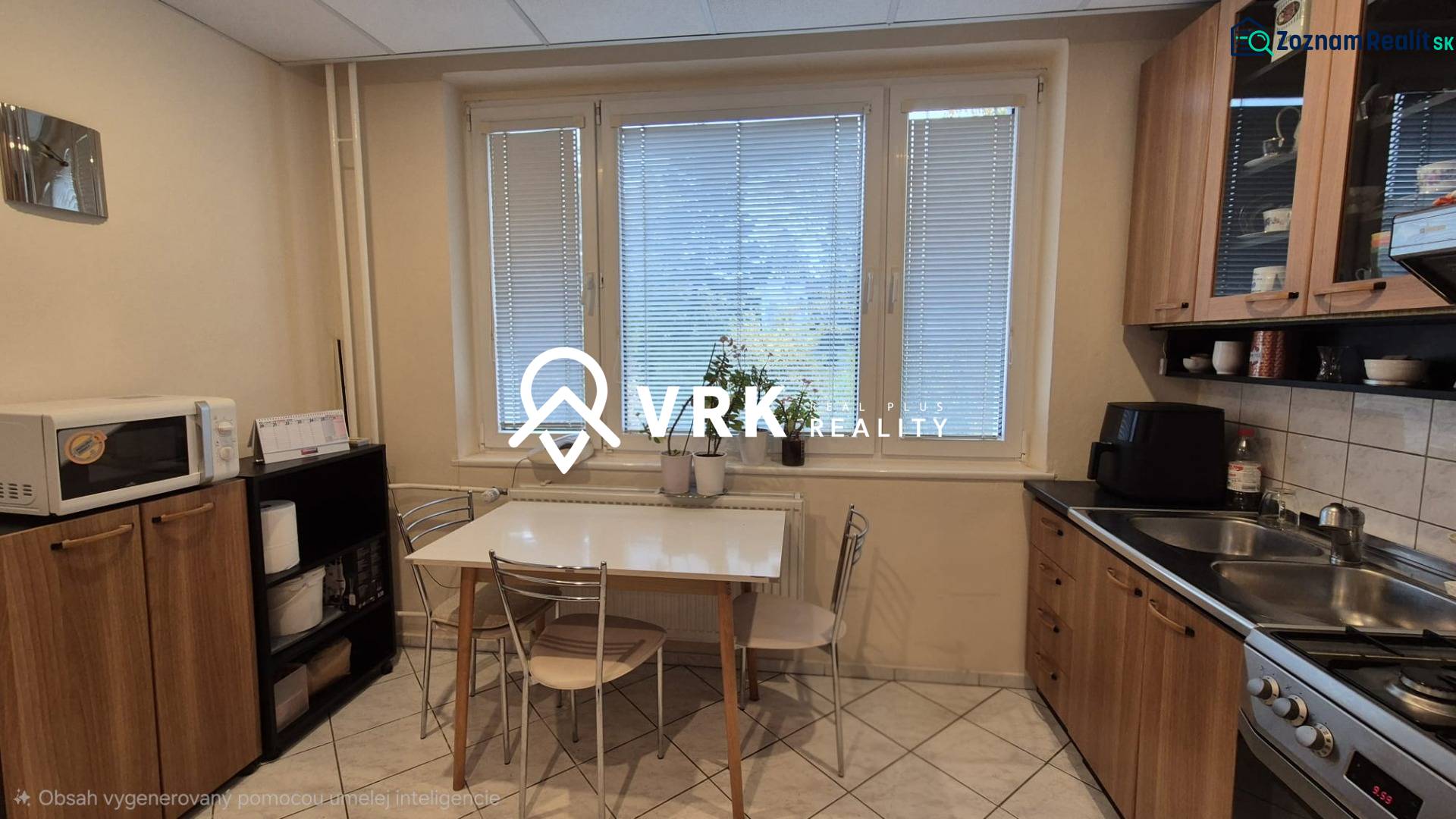 A háromszobás lakás konyhája étkezőasztallal, konyhapulttal és mikrohullámú sütővel.