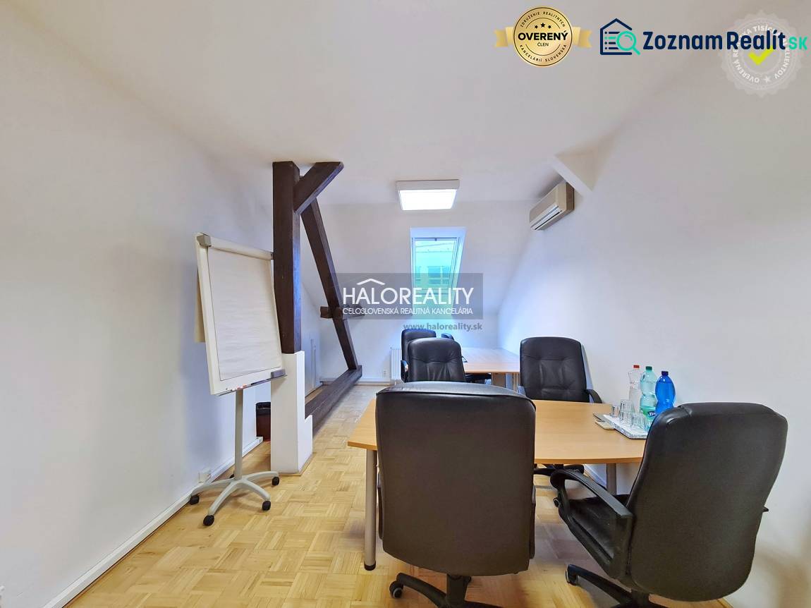 Irodák fa dekor padlóval, asztal, székek, flipchart, víz az asztalon.