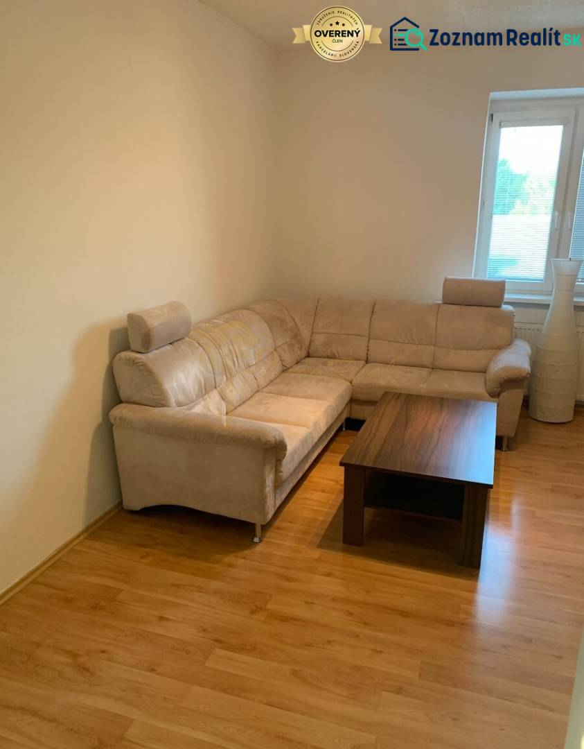 Nappali kényelmes kanapéval és dohányzóasztallal, fa dekorációjú padlón.