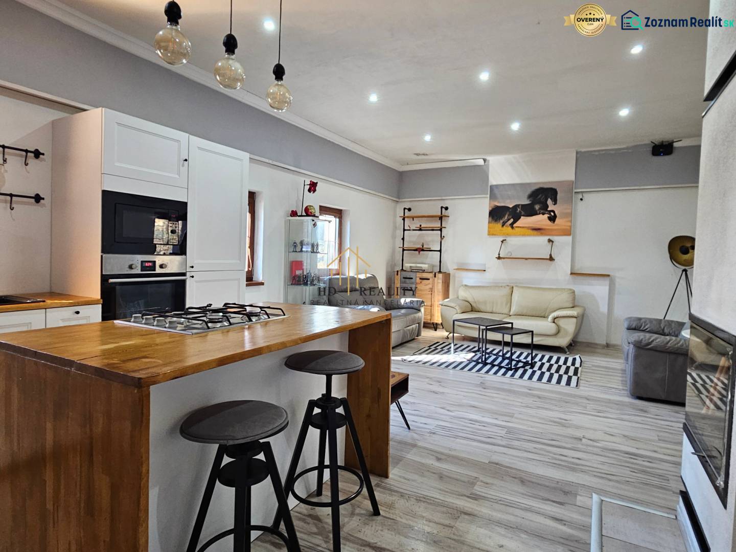 Családi ház belső tere konyhasarokkal, fa dekorációjú padlóval és kényelmes ülőhelyekkel.