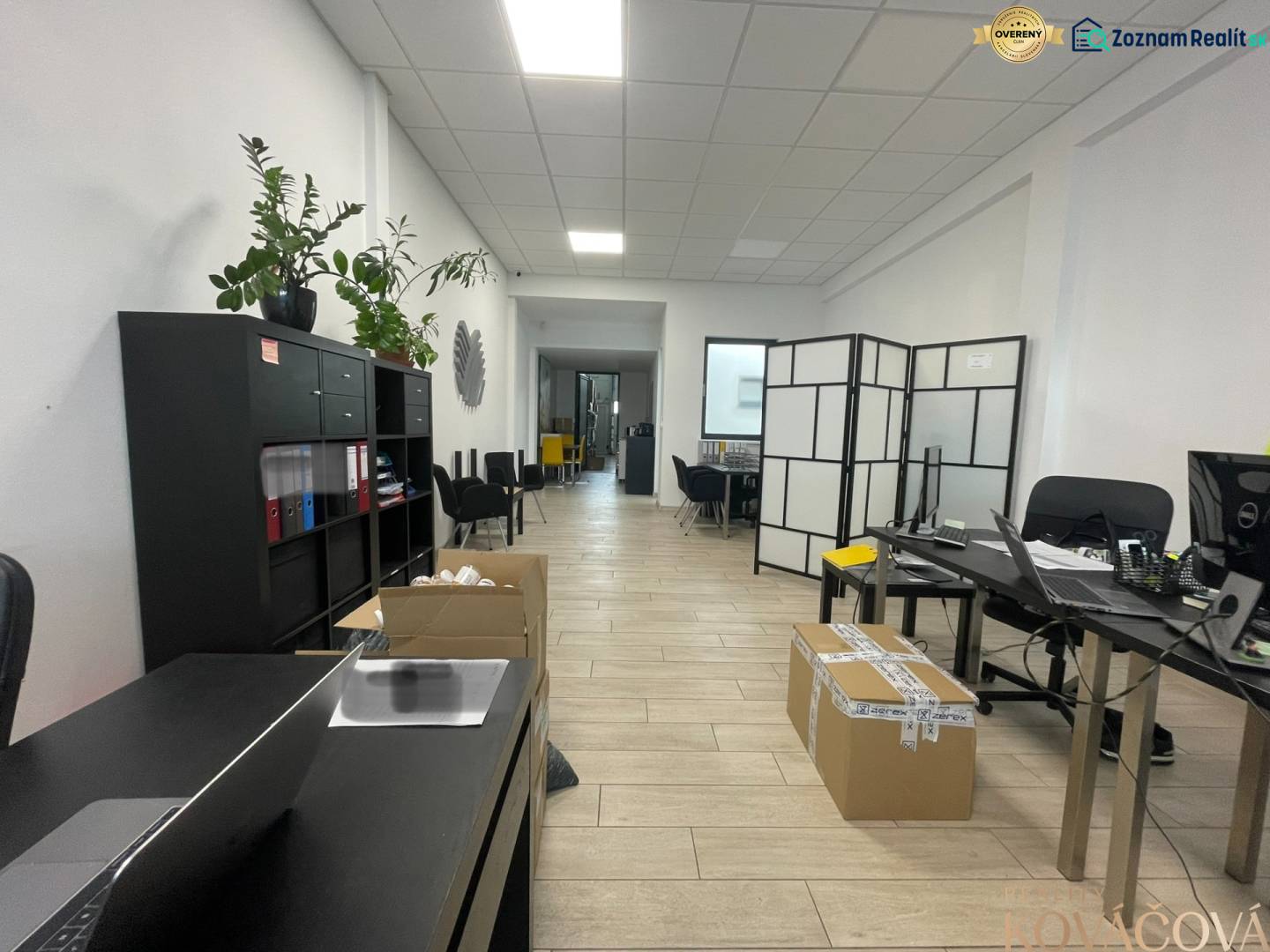 Üzlethelyiség polcokkal, asztalokkal, székekkel és fa dekorációjú padlóval.