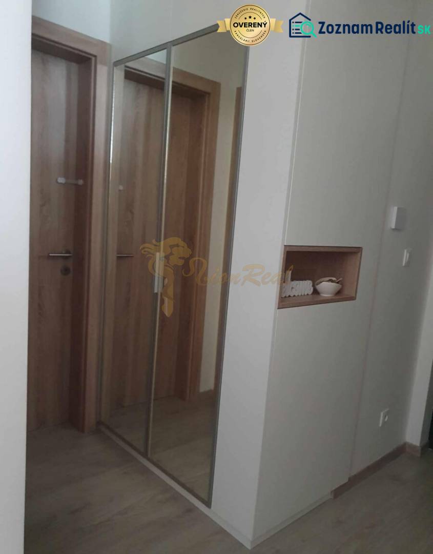 Folyosó nagy tükörrel és fa dekorációjú padlóval egy kétszobás lakásban.