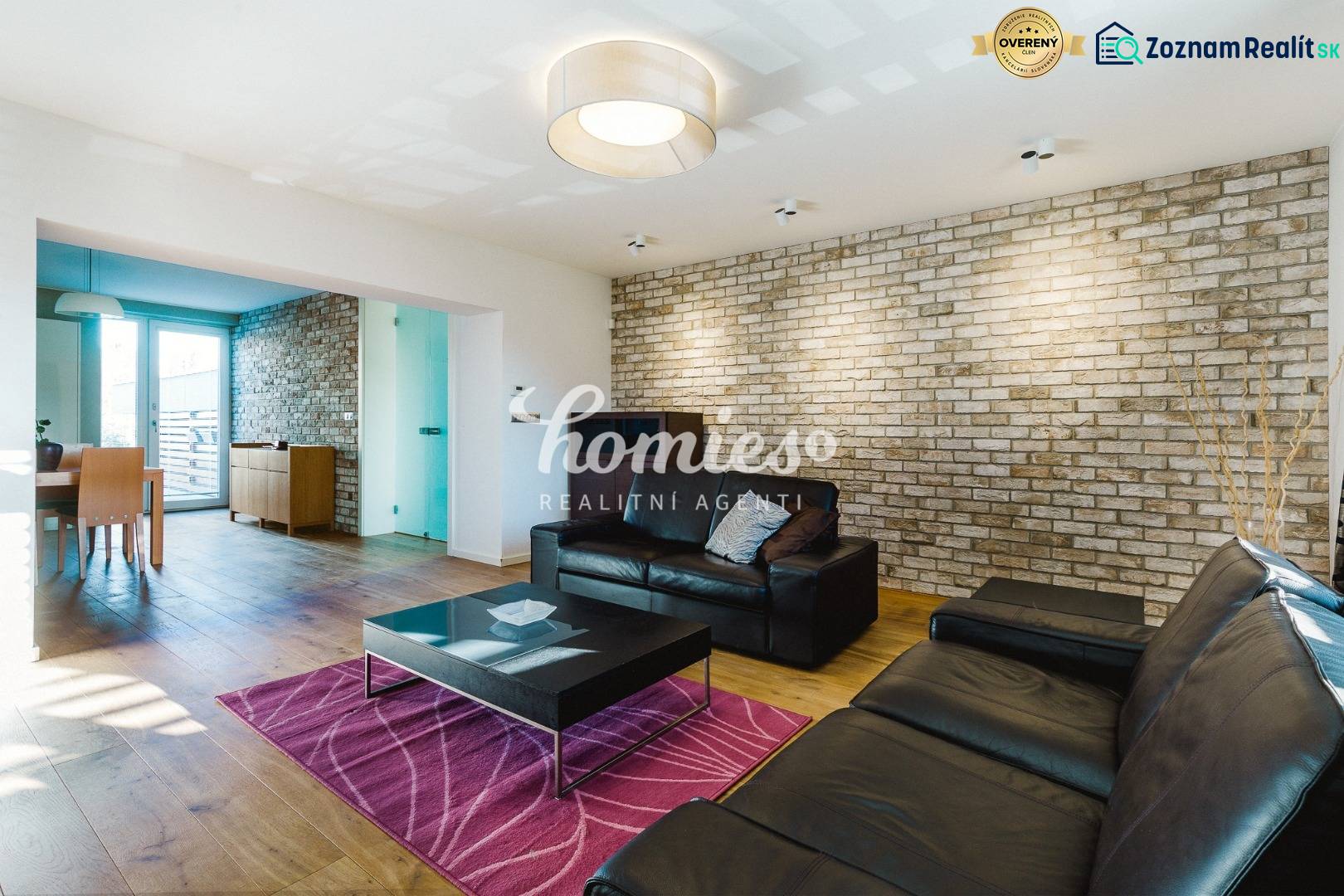 Nappali egy családi házban téglafallal és fa mintázatú padlóval.