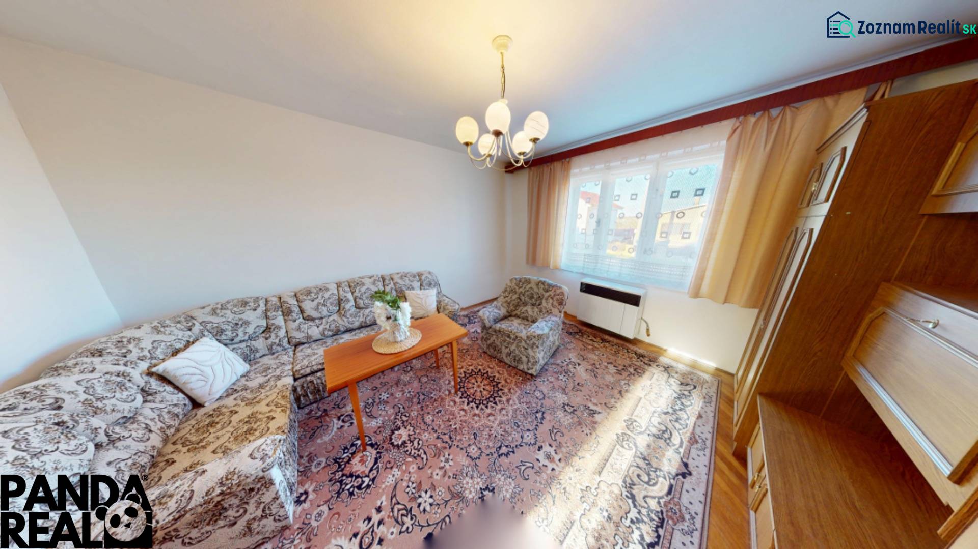 Nappali egy családi házban kanapéval, szőnyeggel és fa szekrényekkel.