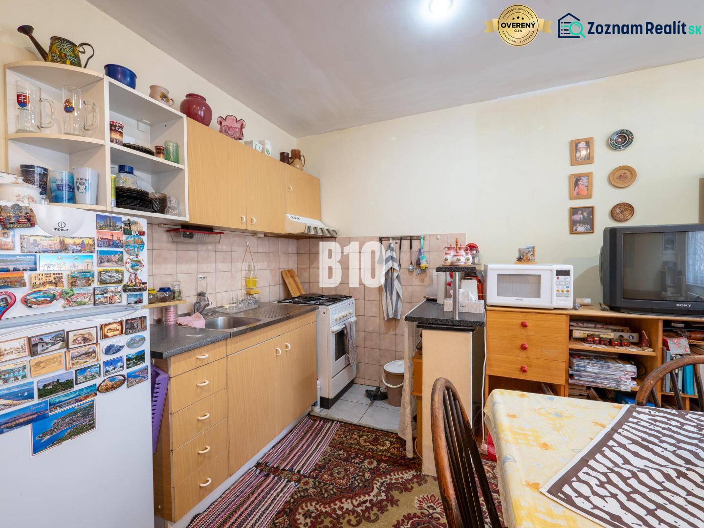 Konyha egy kétszobás lakásban konyhabútorral, háztartási gépekkel és dekorációs tárgyakkal.