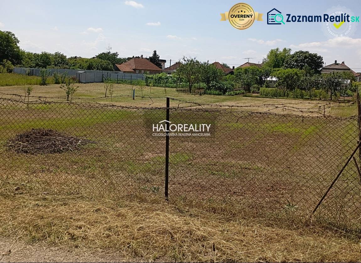 Marcelházi kertek füves felülettel és kerítéssel, háttérben fákkal.