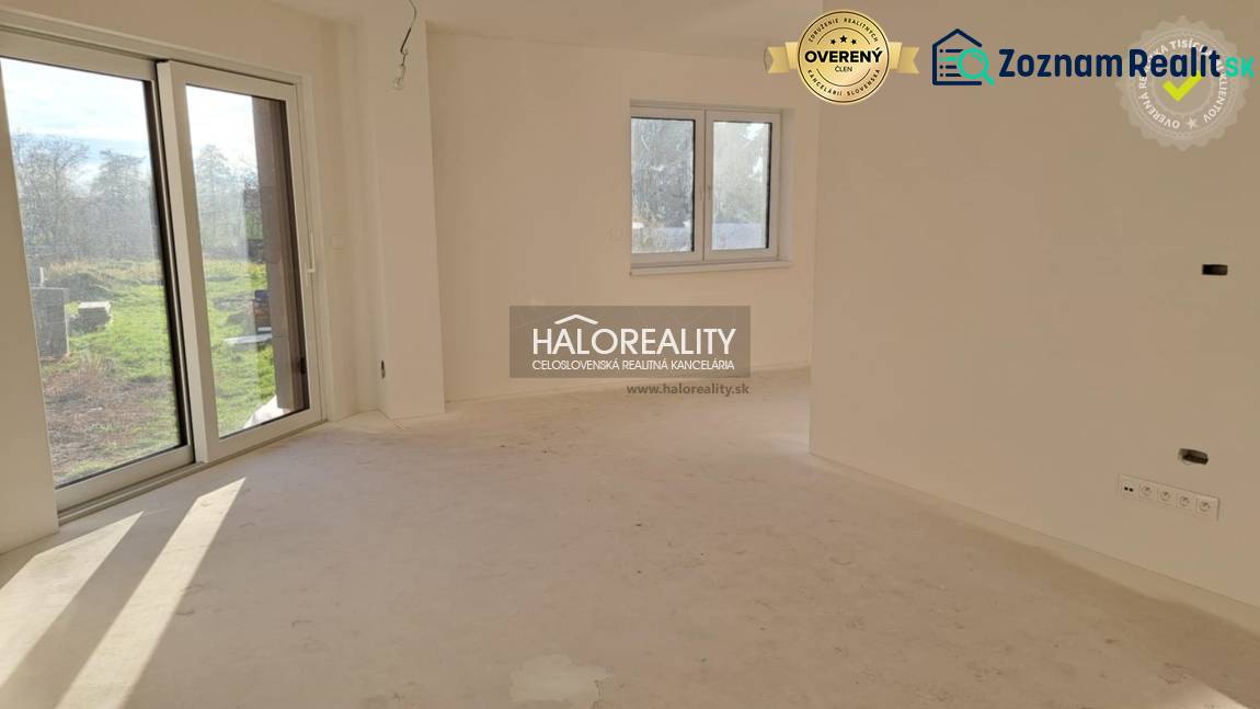 Családi ház belső tere nagy ablakkal, fehér falakkal és teraszajtókkal.