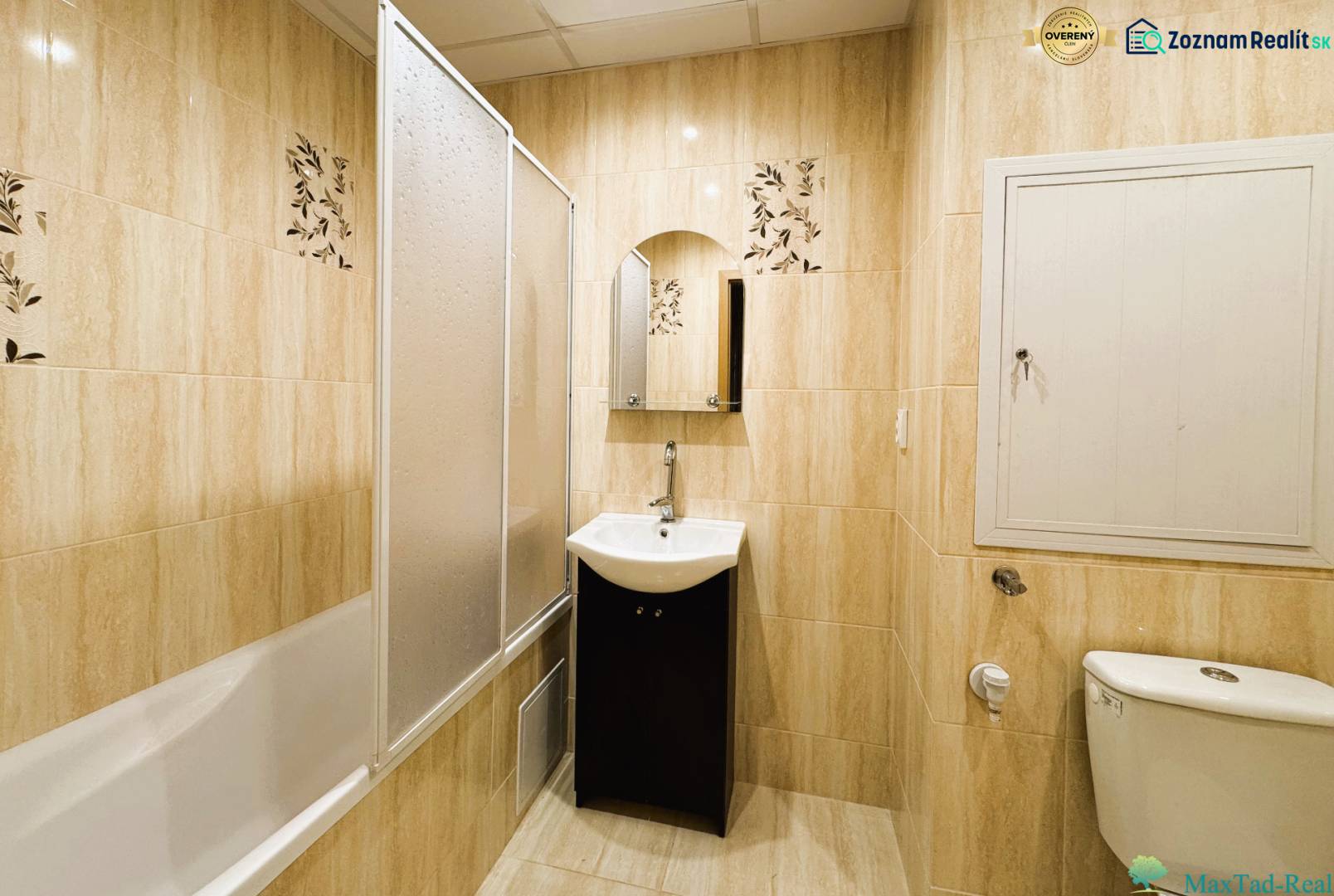 Fürdőszoba káddal, mosdóval és WC-vel egy háromszobás lakásban világos csempékkel.