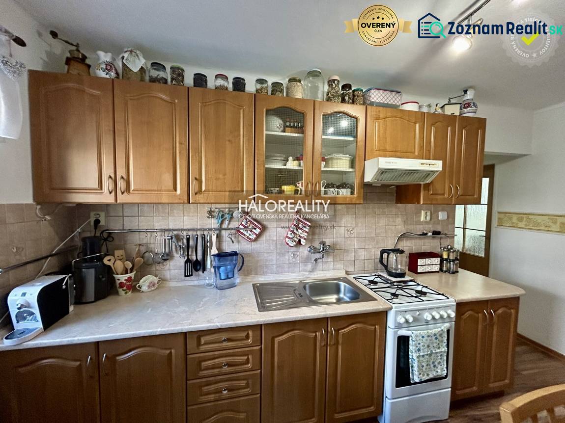 Konyha egy kétszobás lakásban fa dekorációval a padlón és fa szekrényekkel.