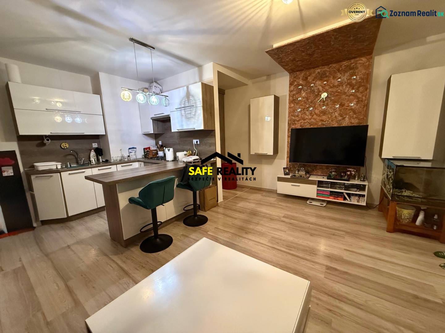 Nappali konyhával, bárpulttal és fa dekorációjú padlóval egy kétszobás lakásban.