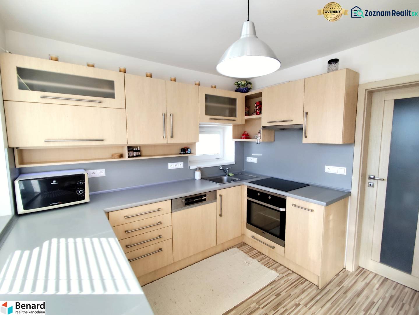 Konyha családi házban fa dekorációval és szürke munkalappal.