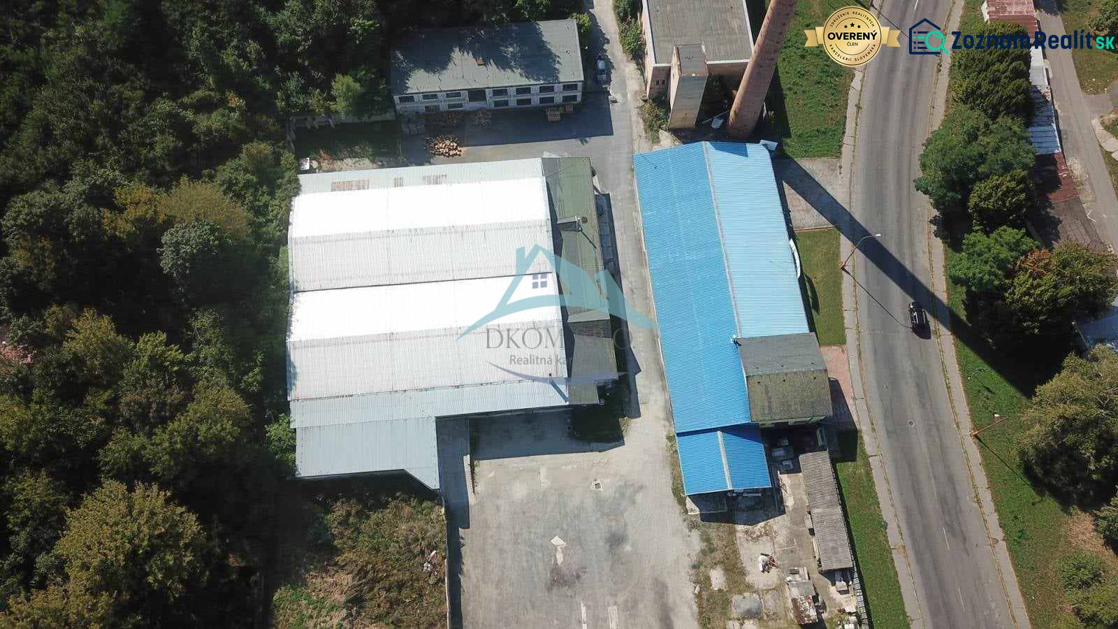 Légi felvétel a csarnokokról és raktárakról a Vasút utca közelében, zöldövezet és földterület által körülvéve.