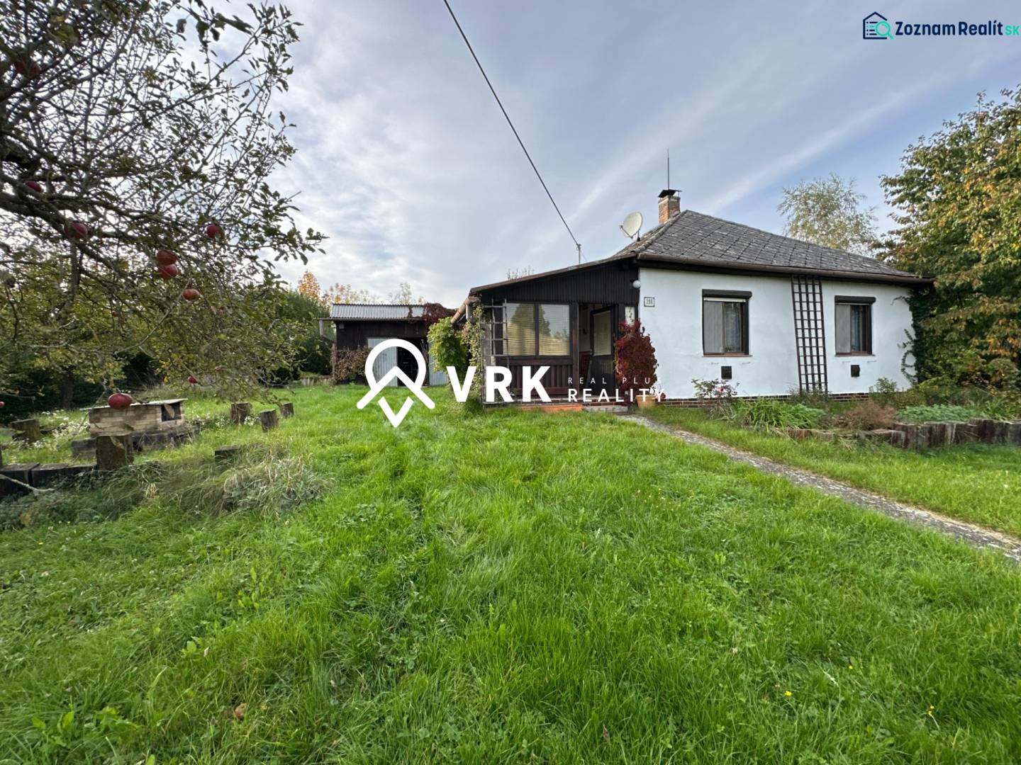 Családi ház Kalšán, kerttel és gyümölcsfákkal körülvéve, rendezett gyepfelülettel.