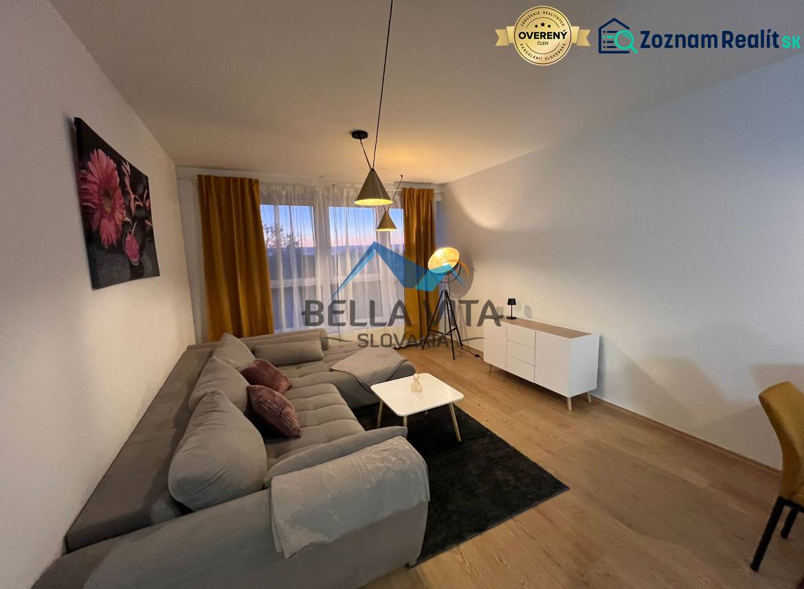 Nappali egy kétszobás lakásban kanapéval és fa dekorációjú padlóval.