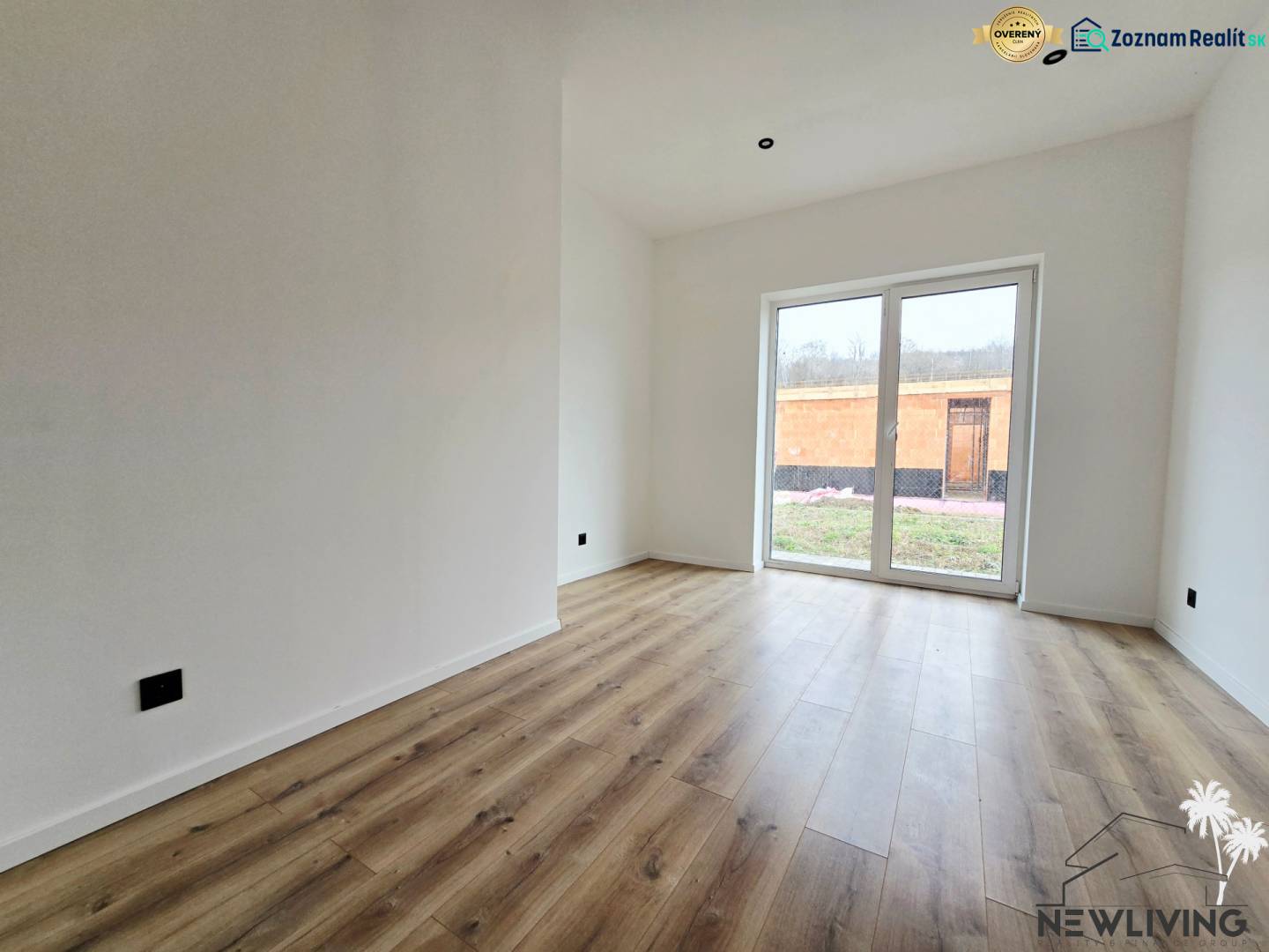 Családi ház fa mintázatú padlóval és nagy ablakokkal a kertre.