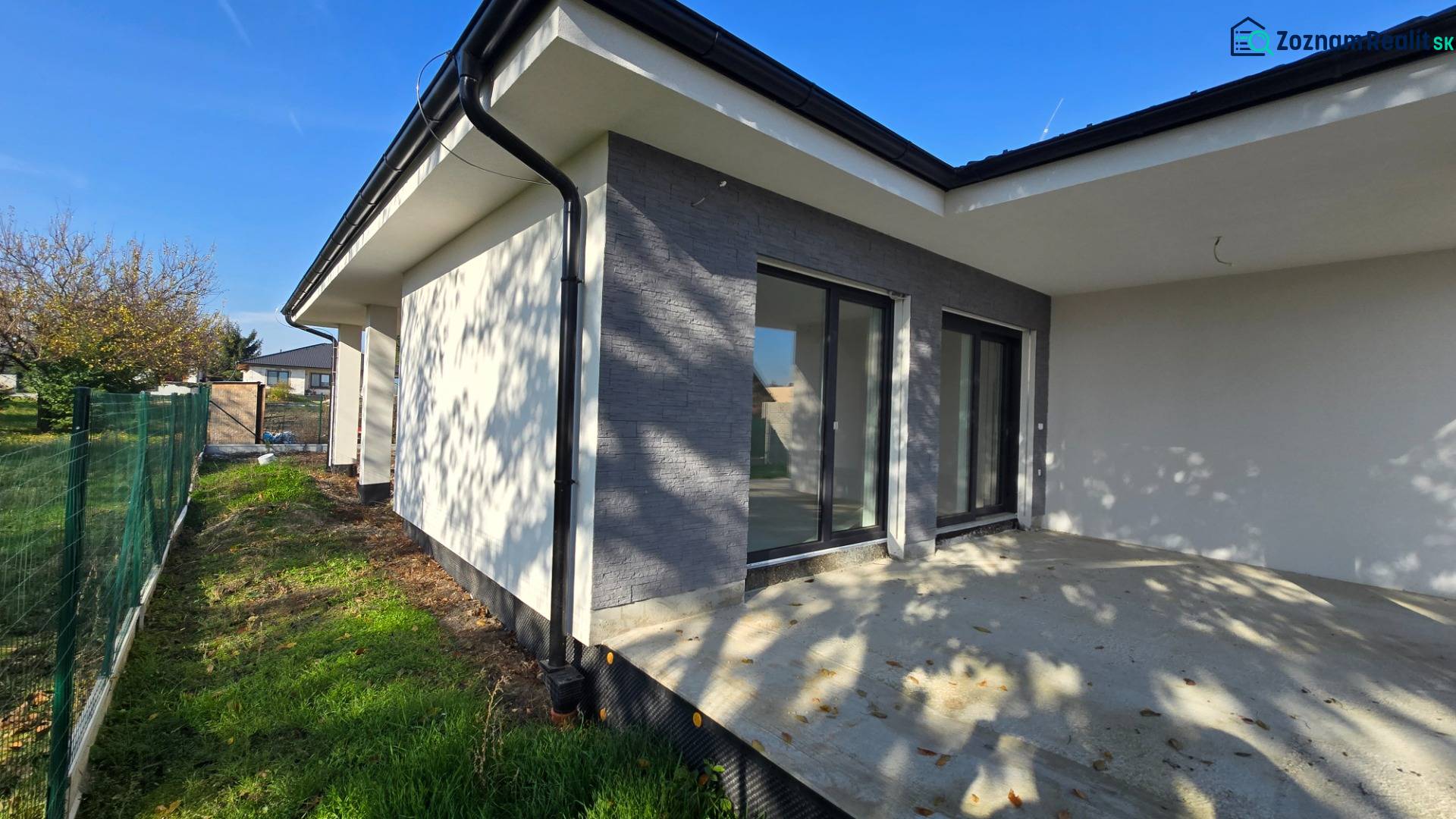 Családi ház Pöstyénben terasszal és kerttel, amelyet zöld kerítés határol.