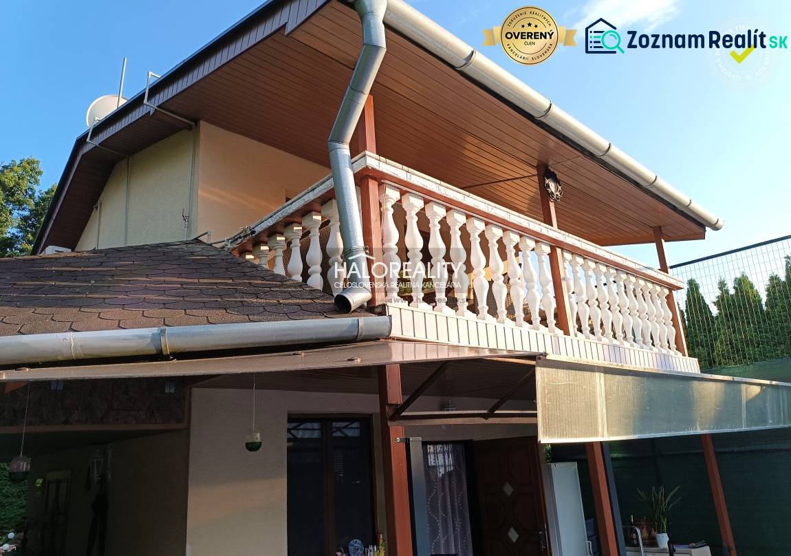 Ház Byštén terasszal és fa dekorációjú erkéllyel.