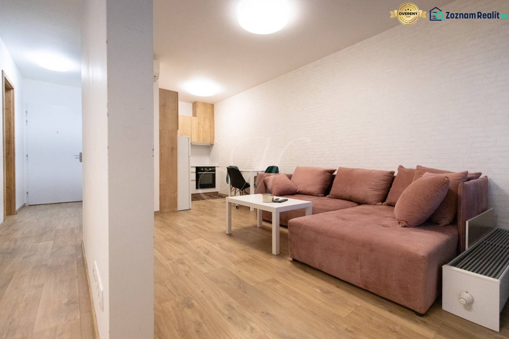 Nappali egy kétszobás lakásban kényelmes kanapéval és fa dekoros padlóval.