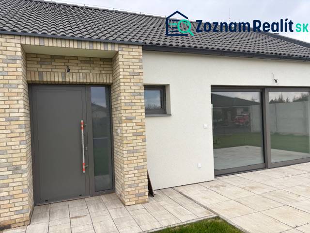Családi ház Tomášovban, a Fialkova utcában, téglaburkolattal és tágas üvegajtókkal.