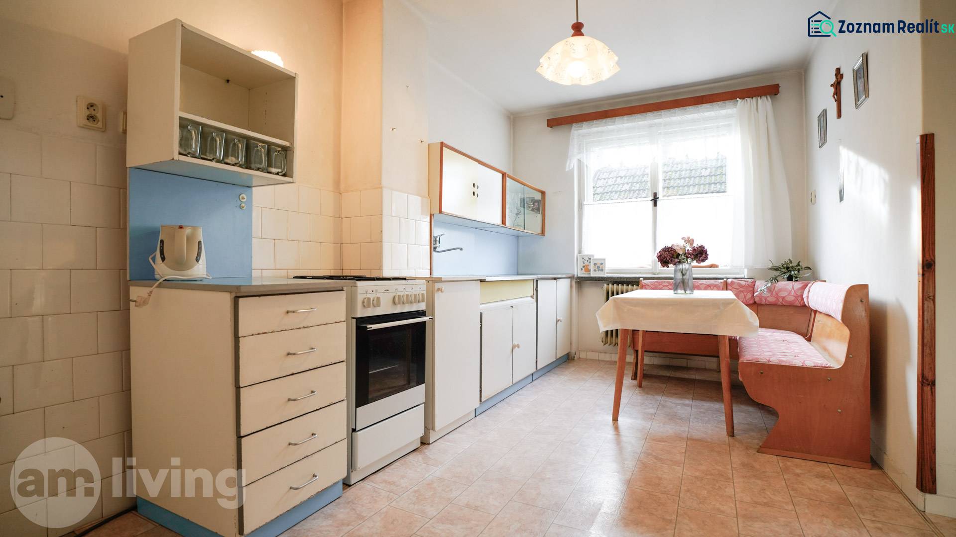 Konyha családi házban klasszikus felszereléssel, sarokban elhelyezett ülőhellyel és ablakkal.