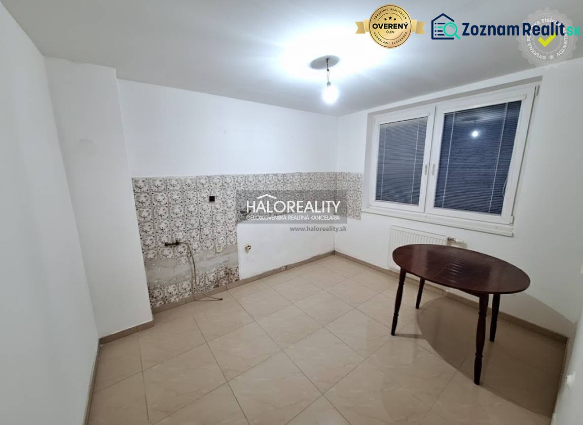 Szoba családi házban fehér falakkal, ablakkal és csempékkel.