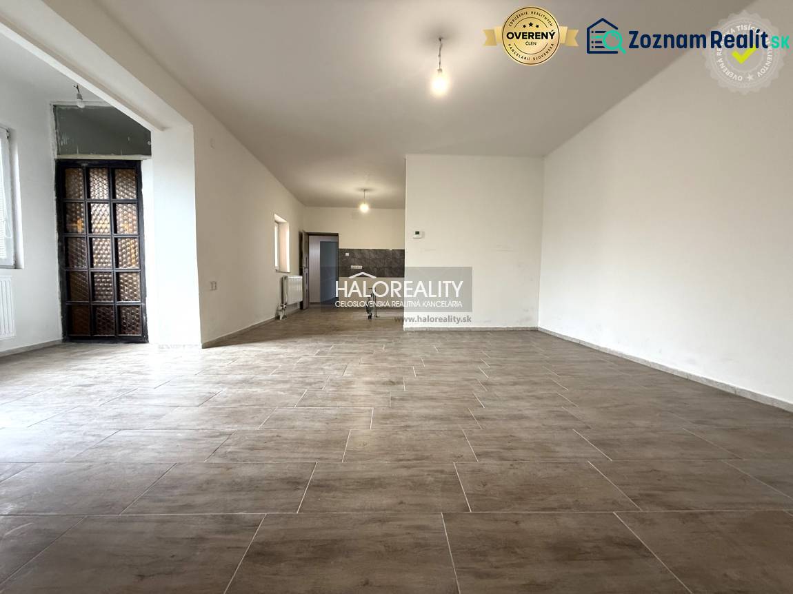 Tágas belső tér nagy ablakokkal és fa dekorációjú padlóval egy családi házban.