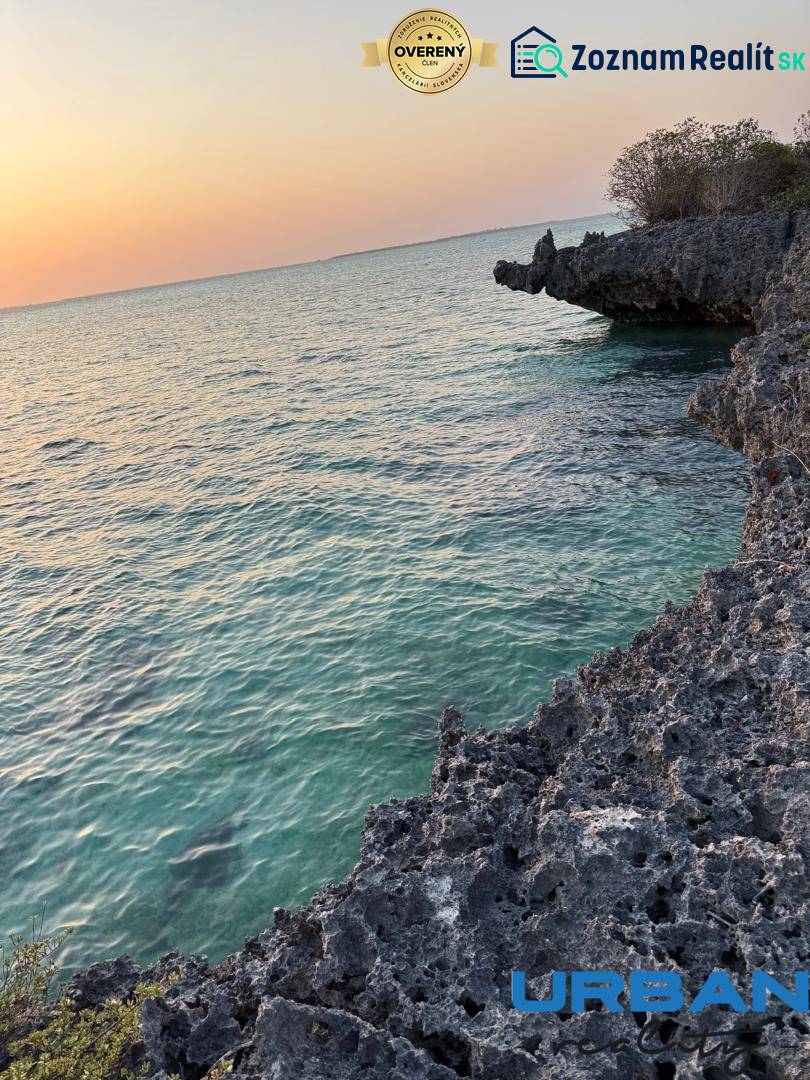 Tengerparti sziklák és naplemente a tenger enyhe hullámai felett Kizimkaziban, Földterületek - kereskedelmi célú.
