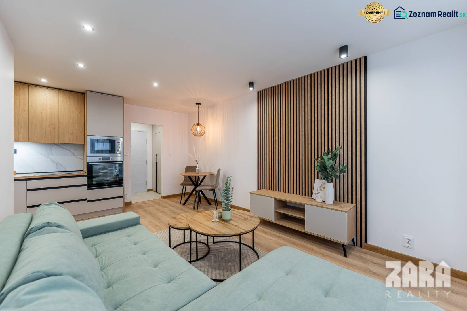 Nappali egy kétszobás lakásban konyhasarokkal és fa dekorációjú padlóval.