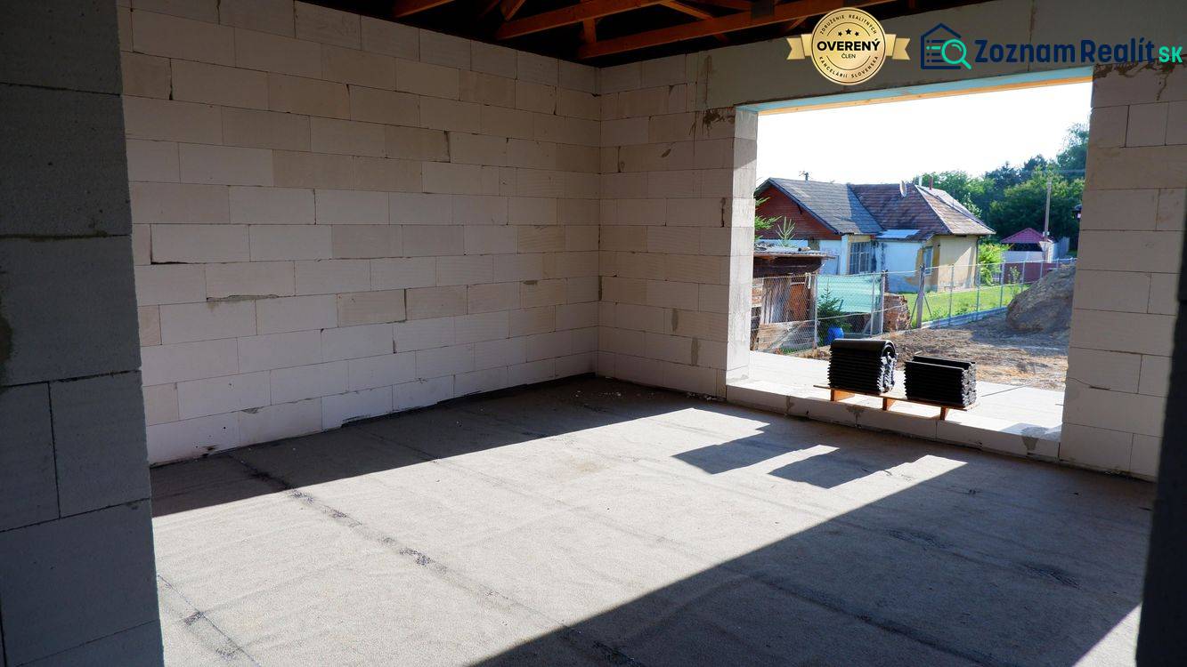 Családi ház építése Radaván, vakolatlan falakkal és környező tájjal.