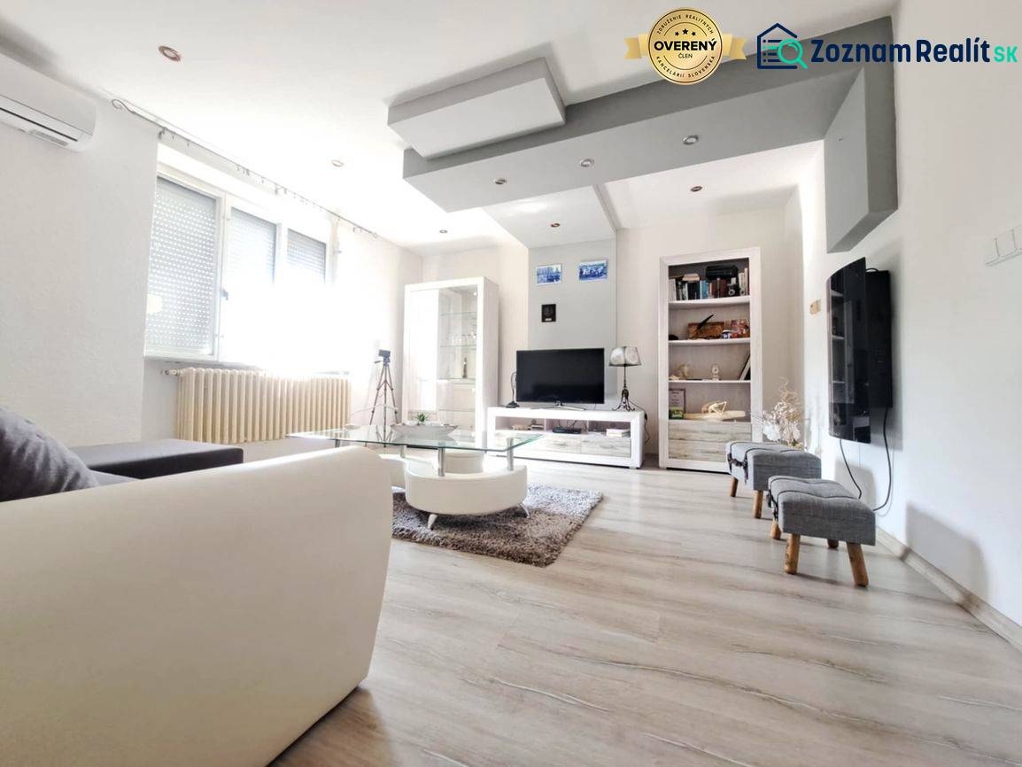 Nappali egy családi házban fa dekor padlóval és kanapéval.