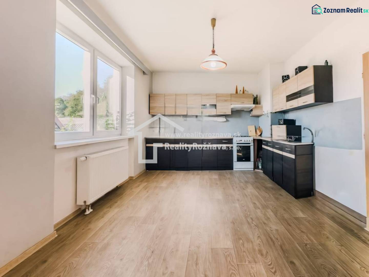 Konyha családi házban, fa dekoros padlóval és nagy ablakkal.