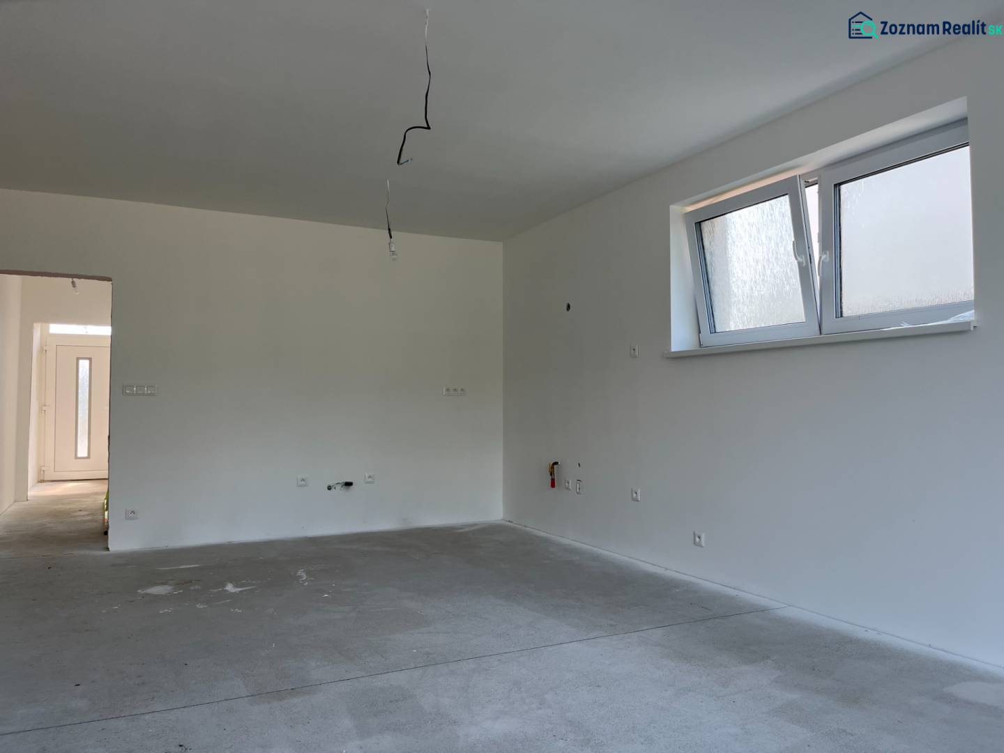 Családi ház belső tere ablakkal, fehér falakkal és elektromos szereléshez szükséges vezetékezéssel.