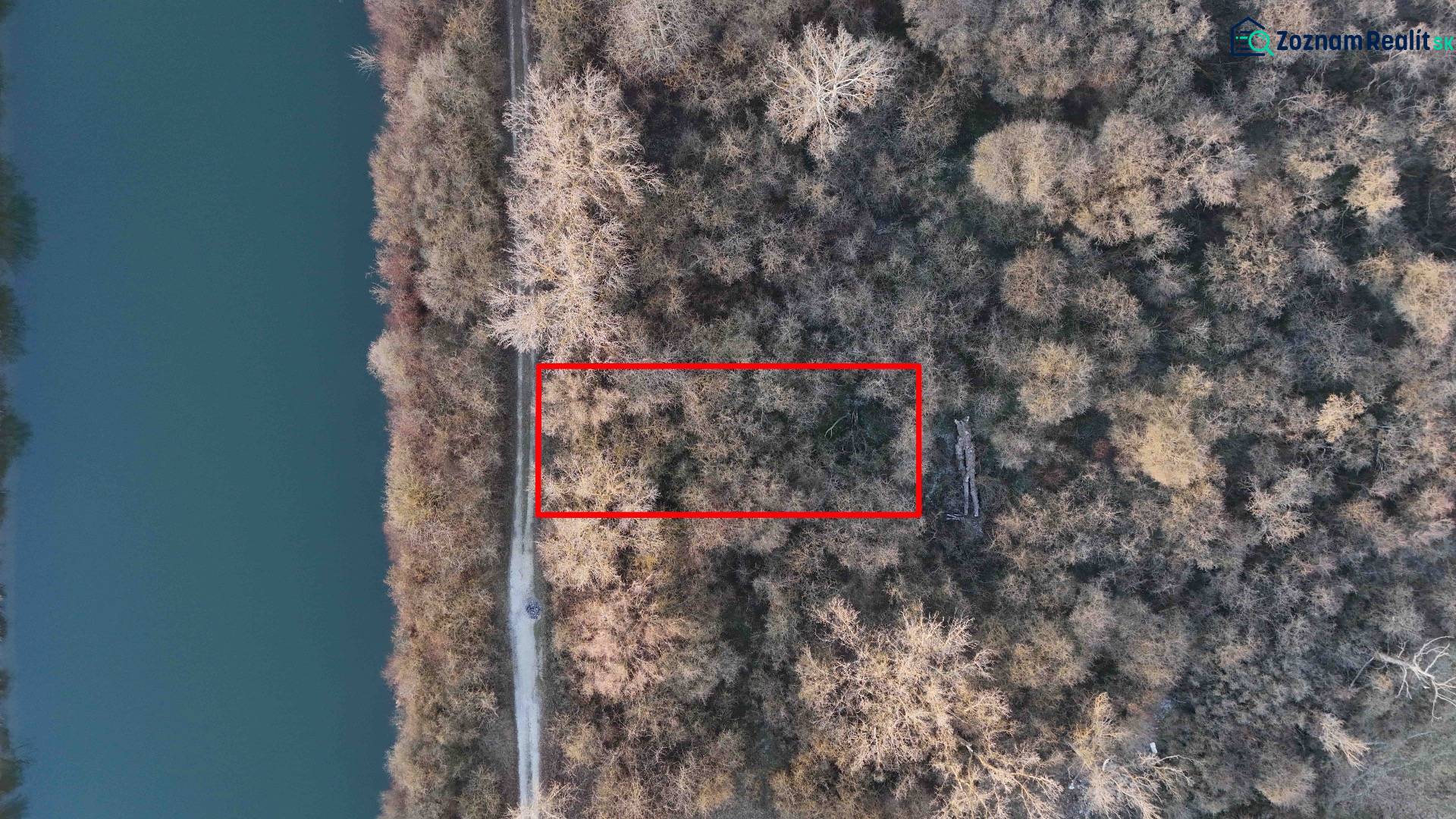 Légi felvétel a rekreációs területekről Újfaluban, amelyeket erdő és folyó vesz körül.