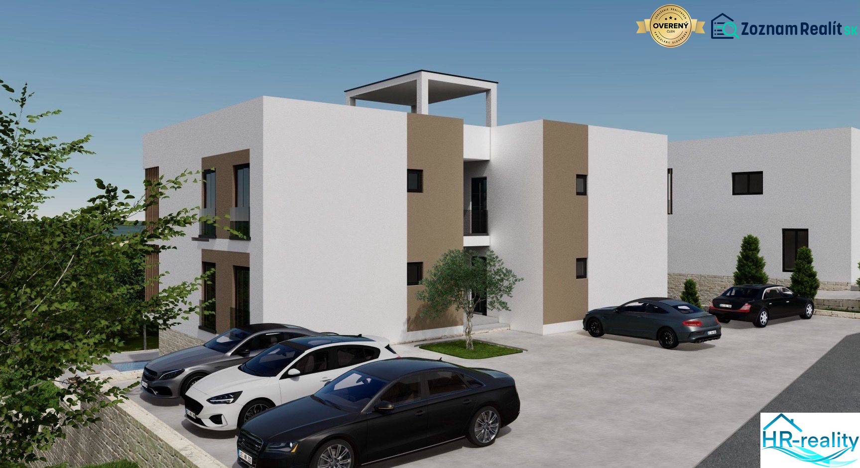 Nyaraló apartman Ciovo szigetén parkoló autókkal és környező zöldterülettel.