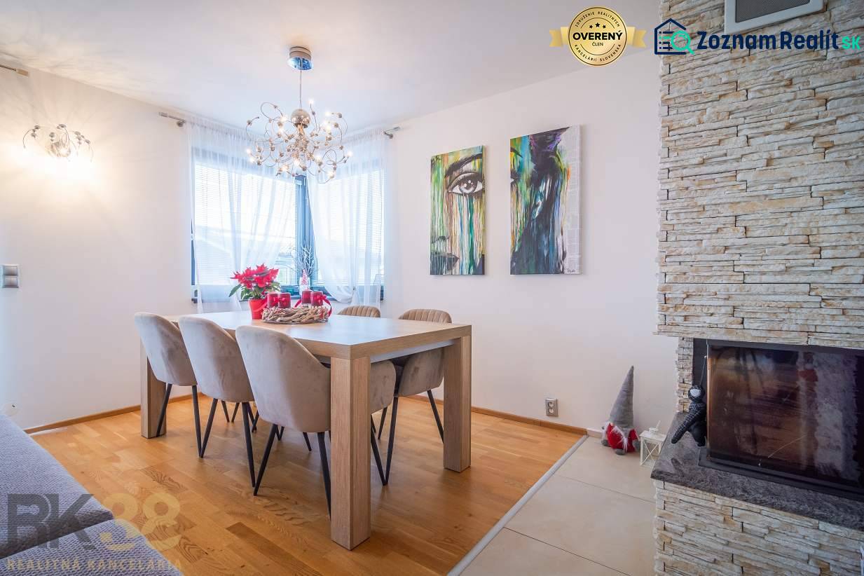 Ebédlő egy családi házban, fa dekorációjú padlóval, kandallóval és fali művészettel.