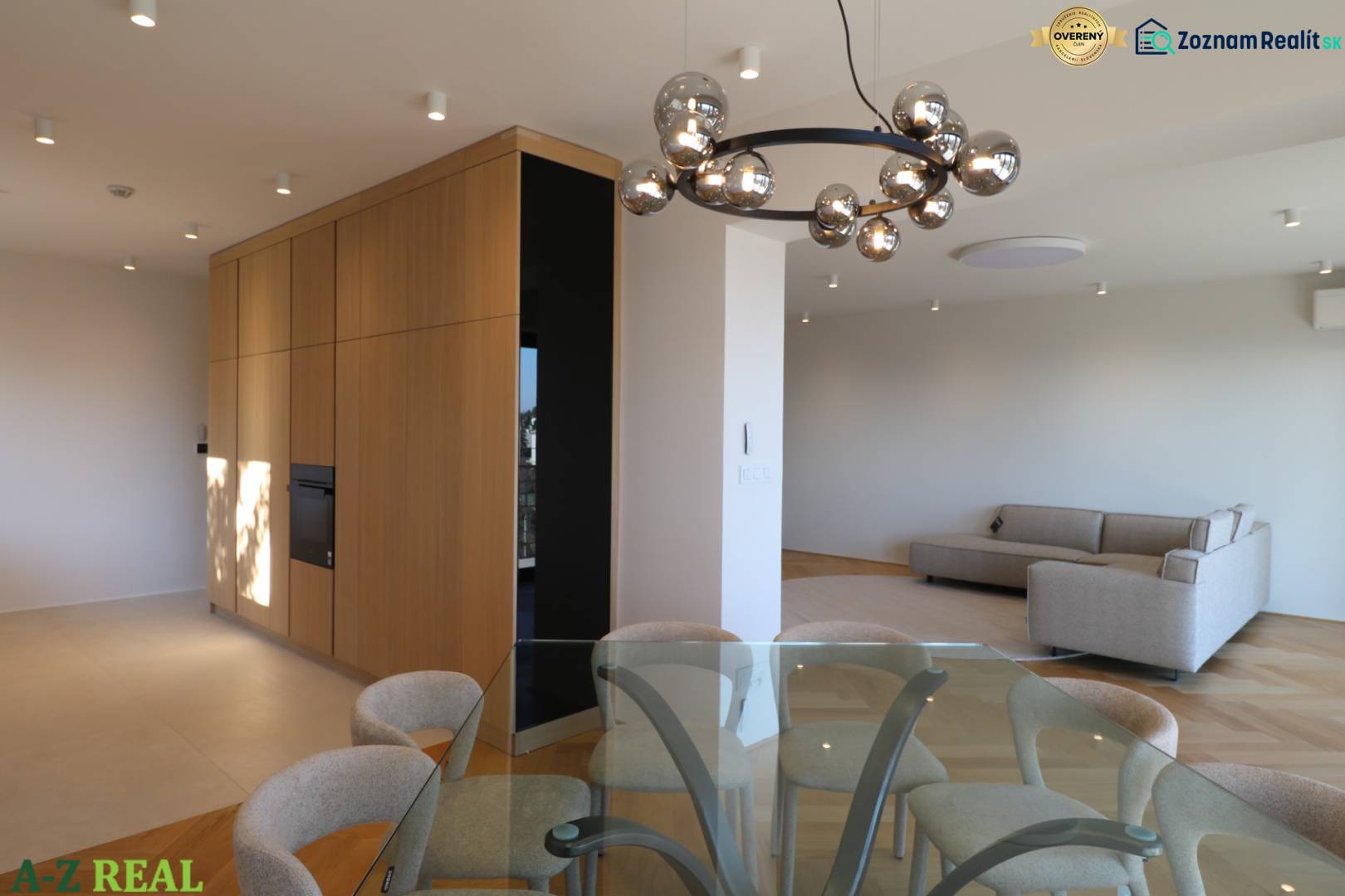 Egy 4 szobás lakás belső tere kanapéval, üvegasztallal és fa dekorációjú padlóval.