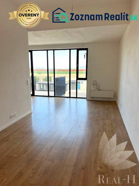 Világos nappali nagy ablakokkal és fa mintázatú padlóval egy kétszobás lakásban.