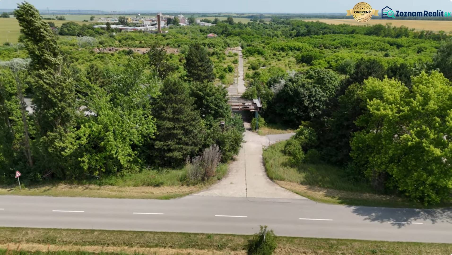 A zölddel szegélyezett út kilátást nyújt a kereskedelmi telkekre Ivanka pri Nitre-ben.