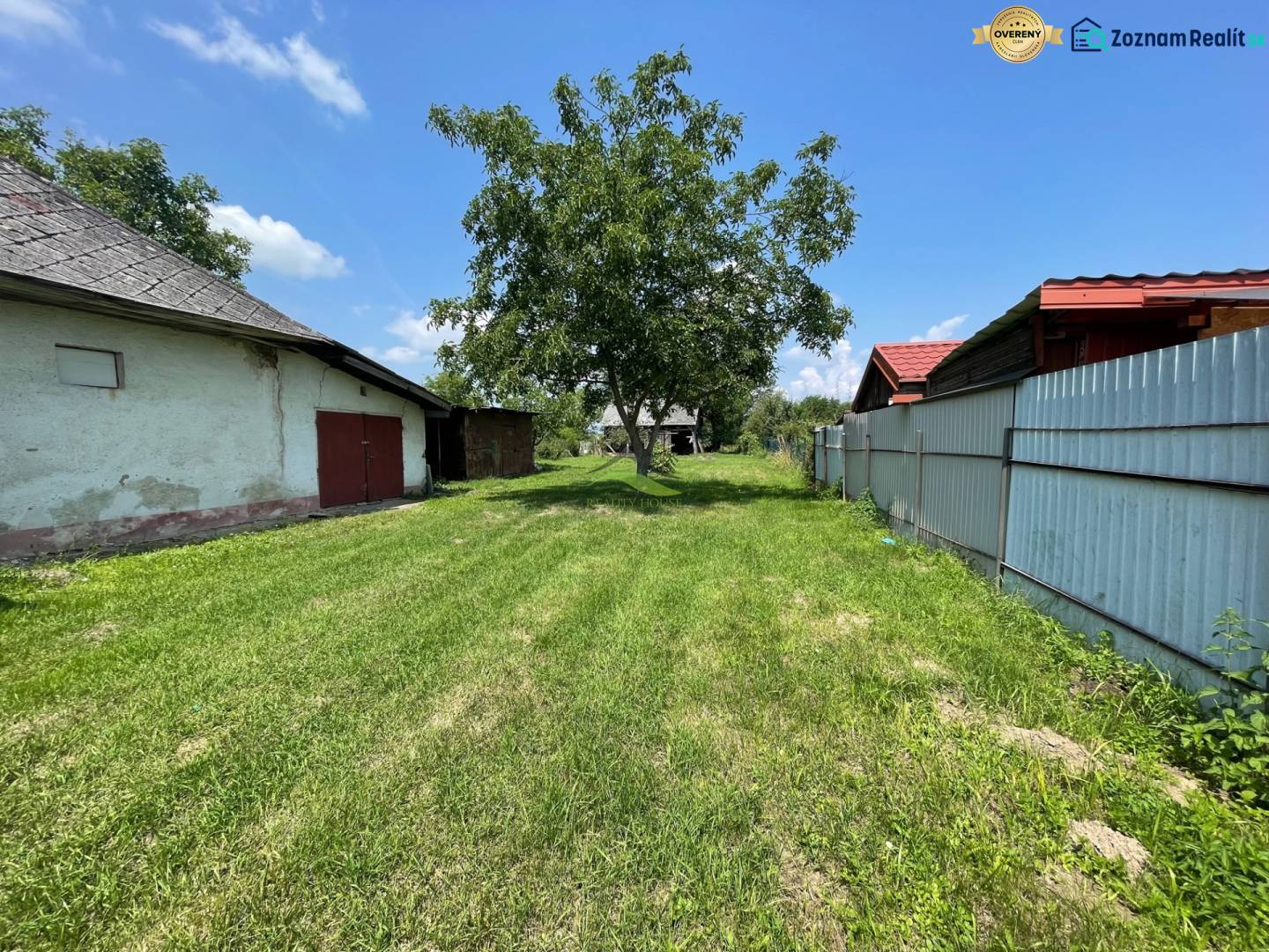 Kilátás egy zöld telekre Zemplínska Širokában, ideális lakhatásra, látható épületekkel.