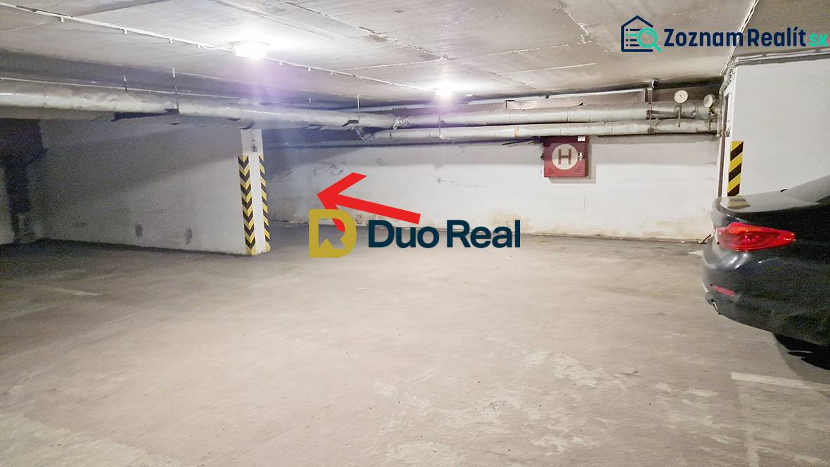 Földalatti parkolóhely a garázsokban, fal melletti parkolóhellyel és autókkal.