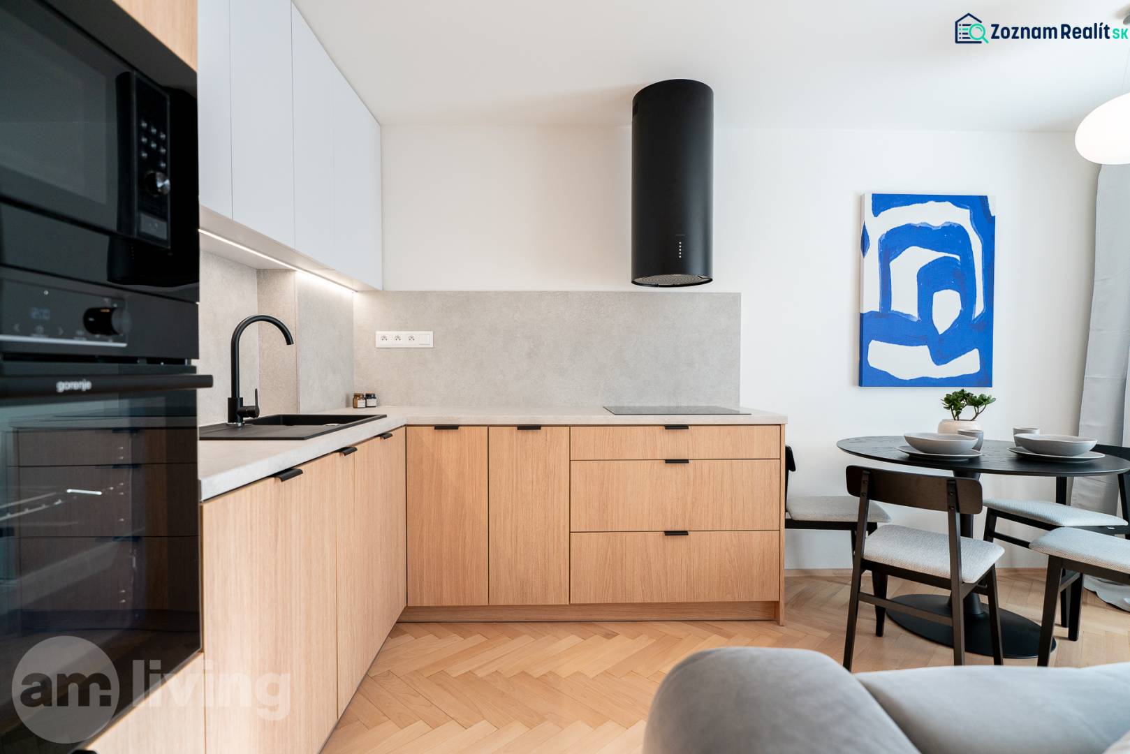 Konyha fa mintázatú padlóval, fa szekrényekkel és étkezőasztallal egy háromszobás lakásban.