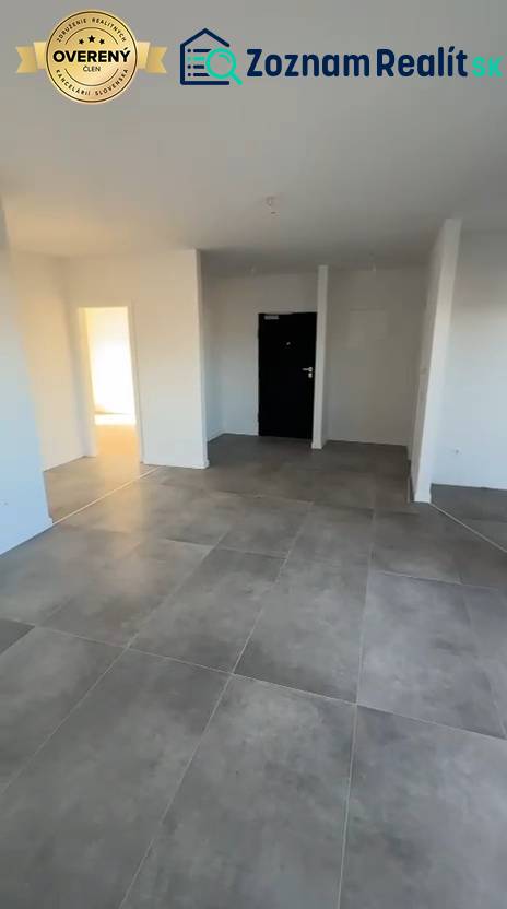 3 szobás lakás belső tere nagy csempékkel és fehér falakkal.