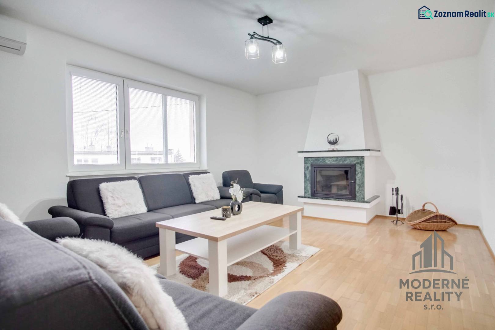Nappali egy 4 szobás lakásban kandallóval és fa dekoros padlóval.