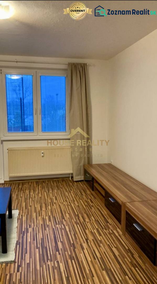 Nappali egy háromszobás lakásban, fa dekorációjú padlóval és kilátással egy nagy ablakon keresztül.